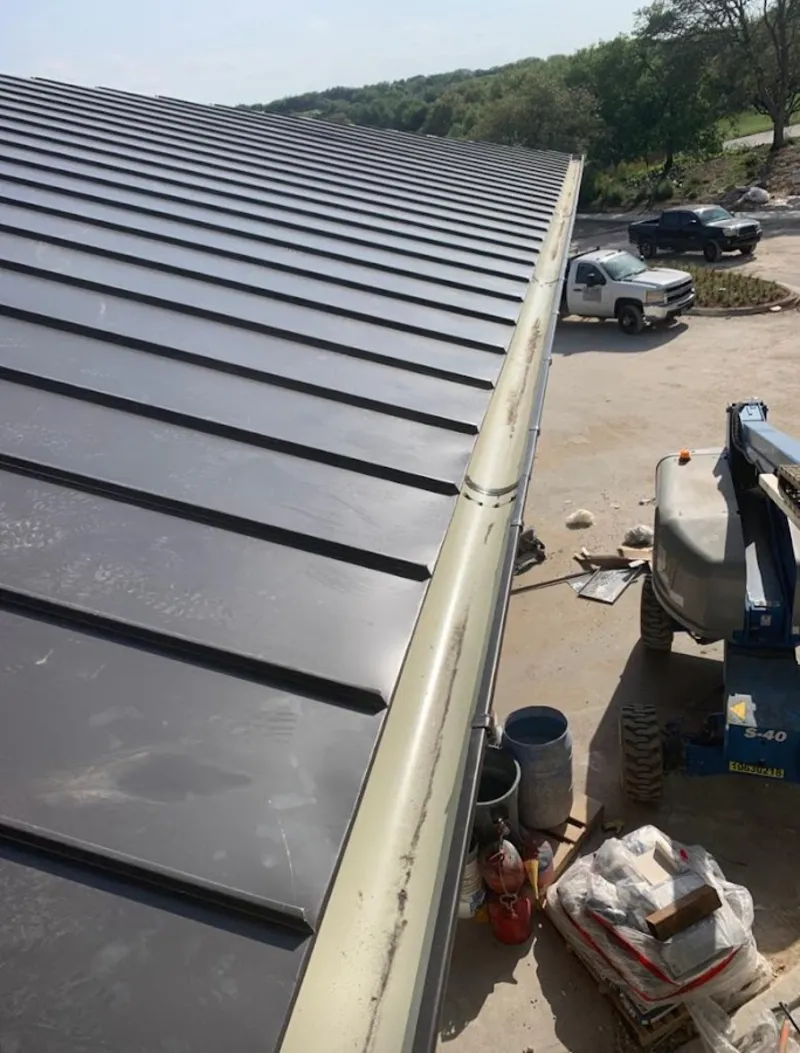 Standing seam panel and gutter detail on a metal roofing jobsite in Palatka